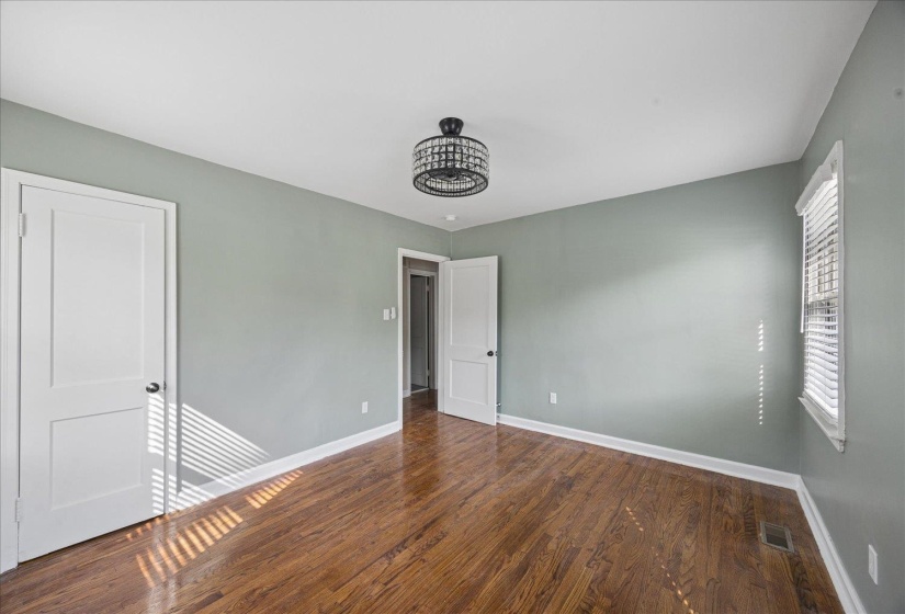 Unfurnished bedroom featuring dark wood finished floors and baseboards