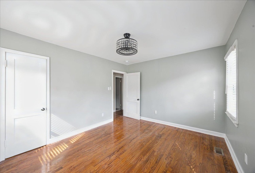 Unfurnished bedroom with dark wood-style flooring and baseboards