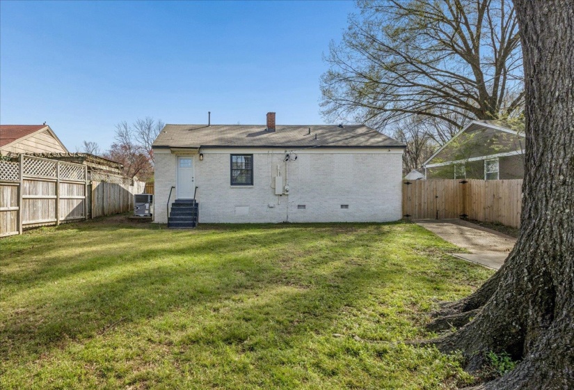 Back of house with crawl space, brick siding, a gate, a chimney, and a fenced backyard