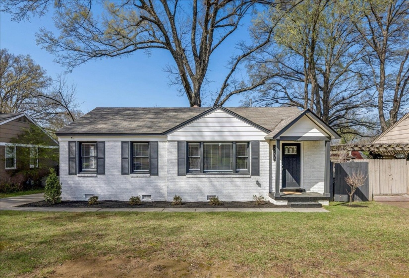 View of front facade featuring brick siding, a shingled roof, and crawl space