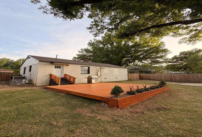 Back of house featuring a wooden deck and brick siding