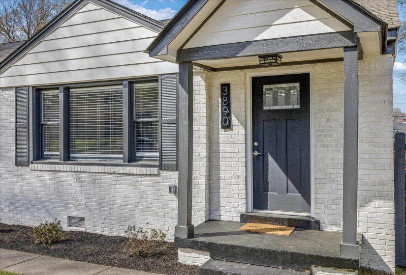 View of exterior entry with brick siding and crawl space