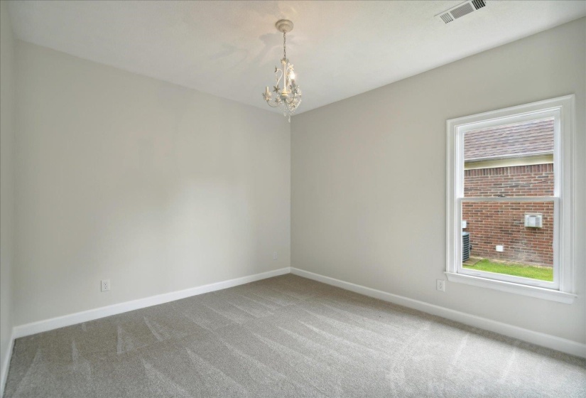Carpeted spare room featuring an inviting chandelier