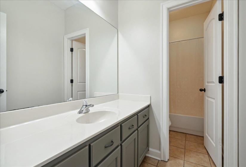 Full bathroom with tile patterned flooring,  shower combination, toilet, and vanity