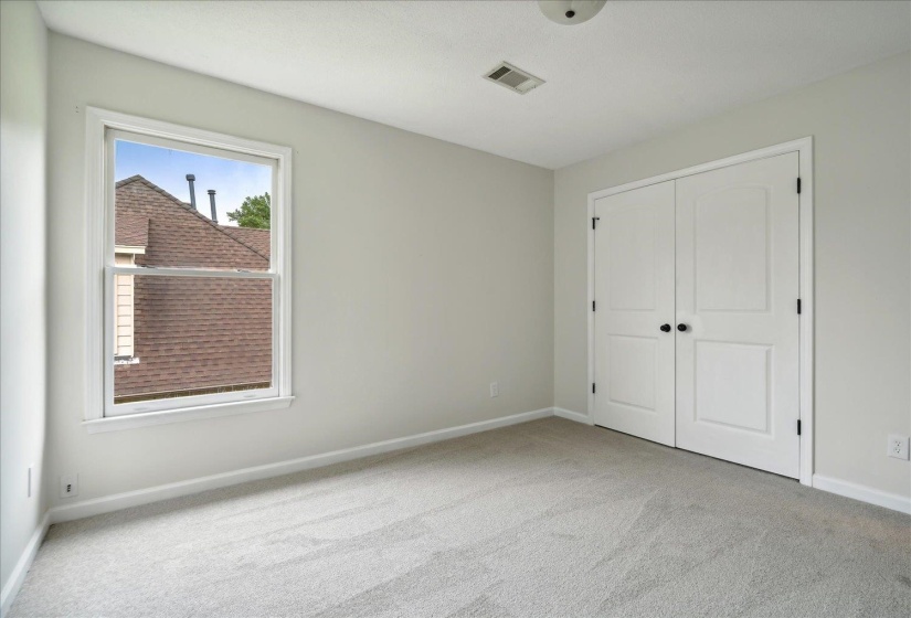 Unfurnished bedroom featuring light carpet and a closet