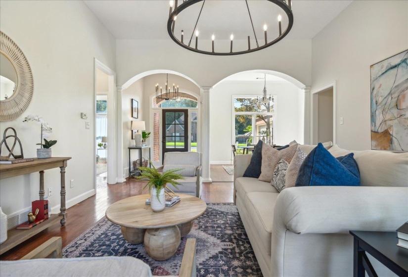 Living room featuring ornate columns and dark wood-type flooring