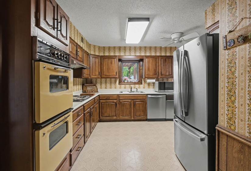 Kitchen featuring stainless steel appliances, light floors, light countertops, a textured ceiling, and ceiling fan