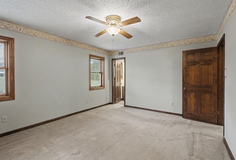 Unfurnished room with a ceiling fan, light carpet, and a textured ceiling