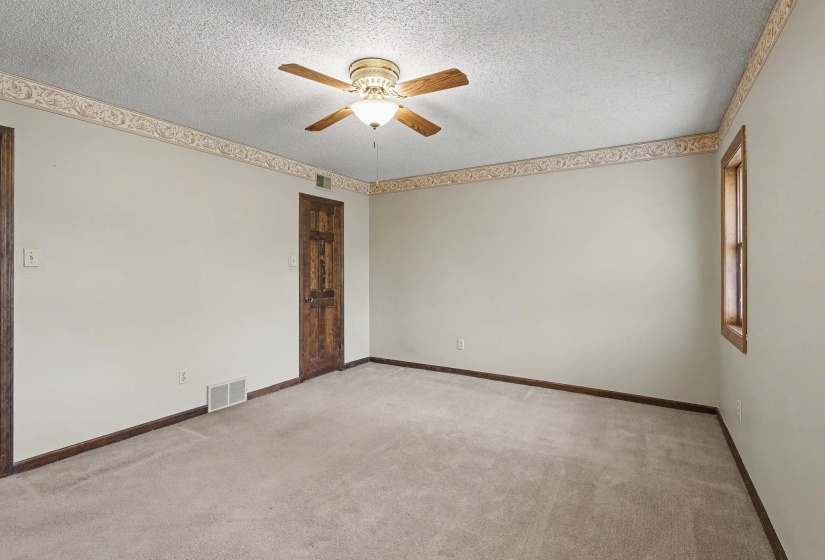 Unfurnished room with ceiling fan, light colored carpet, and a textured ceiling