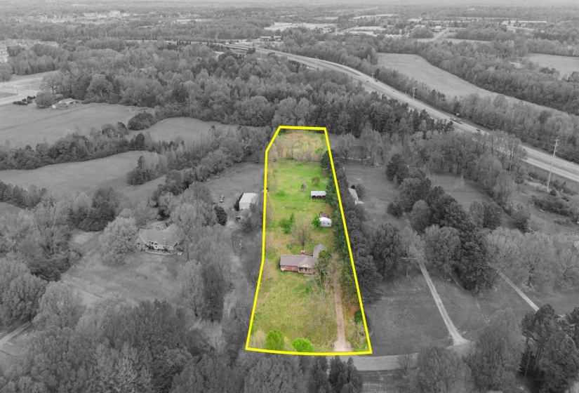 Overview of rural landscape featuring property parcel outlined and a heavily wooded area