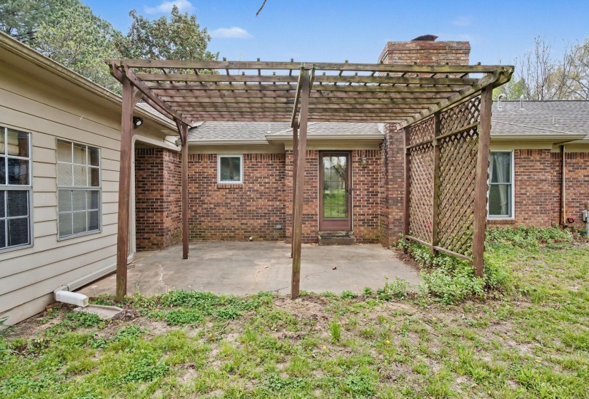 Back of property featuring brick siding, a pergola, and a patio area