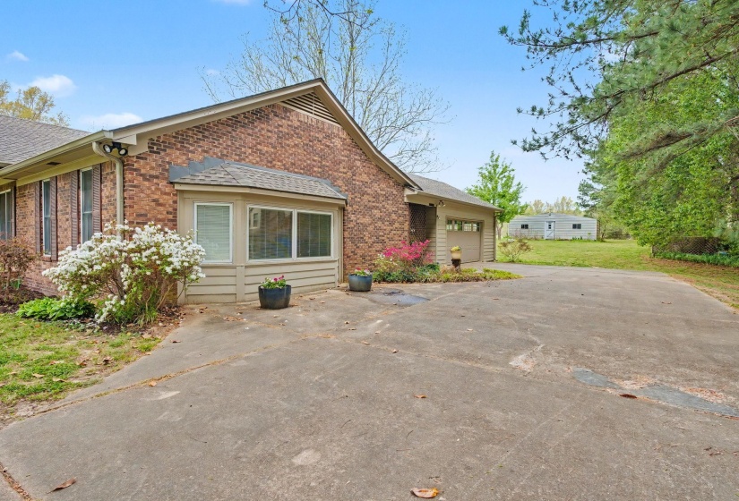 View of front of house featuring brick siding, an attached garage, concrete driveway, and a shingled roof