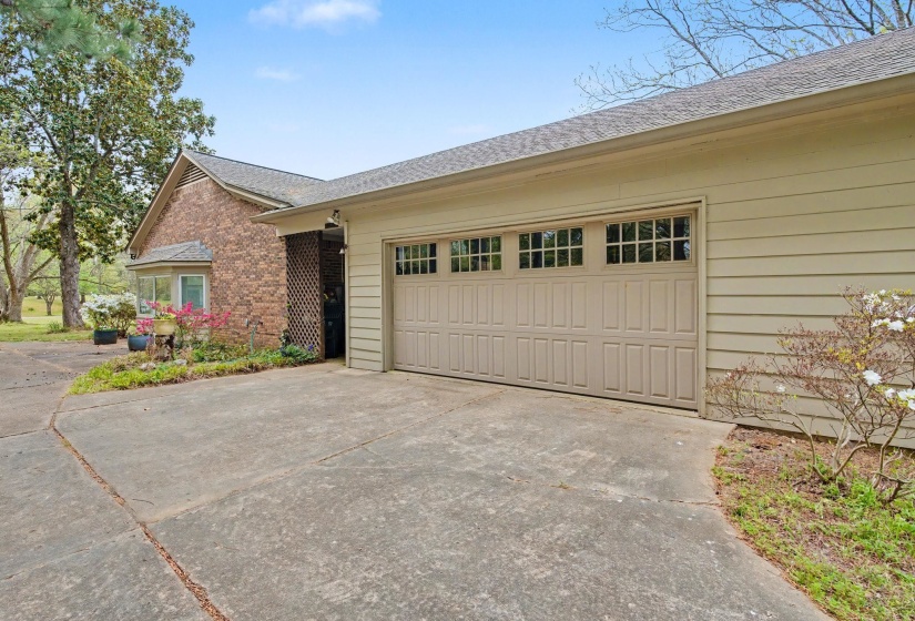 Ranch-style house featuring driveway, roof with shingles, a garage, and brick siding