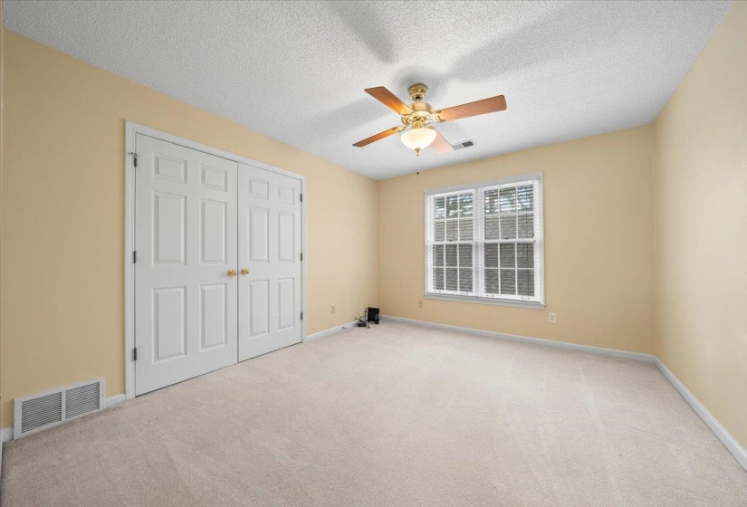 Unfurnished bedroom featuring carpet flooring, a textured ceiling, ceiling fan, and a closet