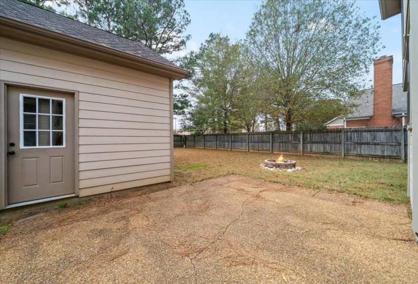 Fenced backyard with an outdoor fire pit