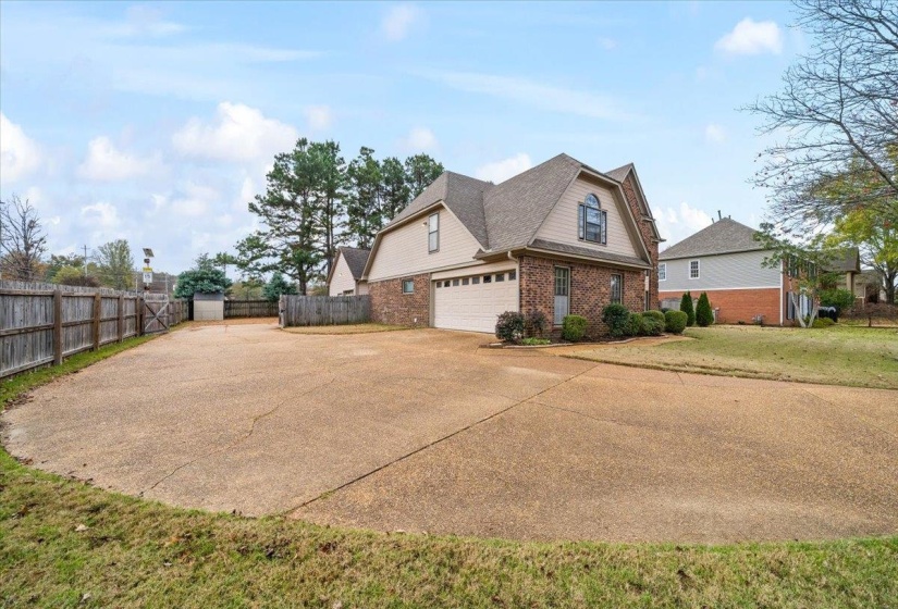 View of side of property featuring brick siding, concrete driveway, a shingled roof, and a garage