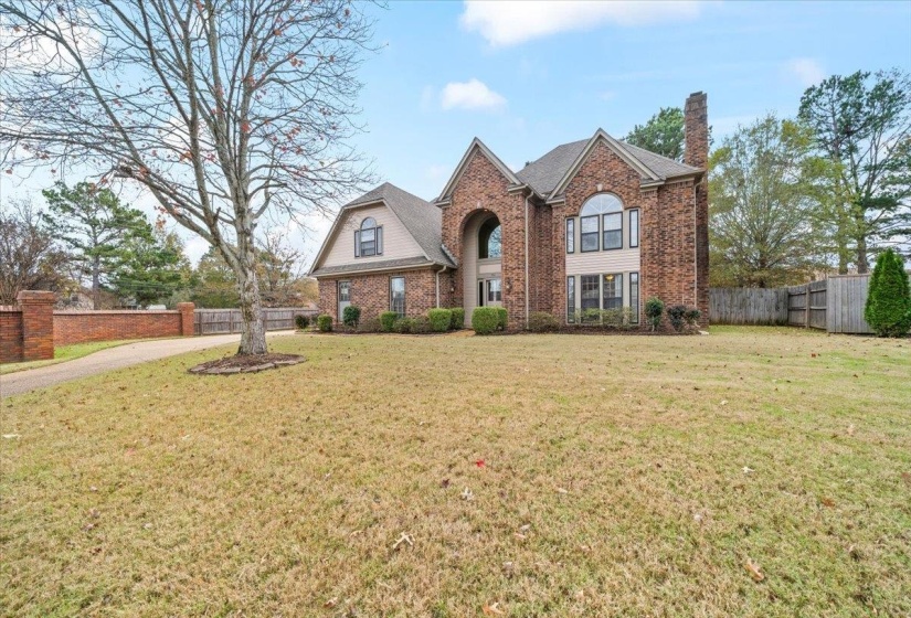 View of front of home featuring brick siding and a chimney