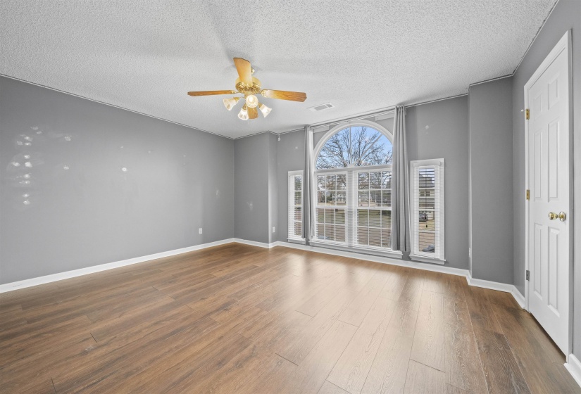 Spare room with a textured ceiling, ceiling fan, and wood finished floors