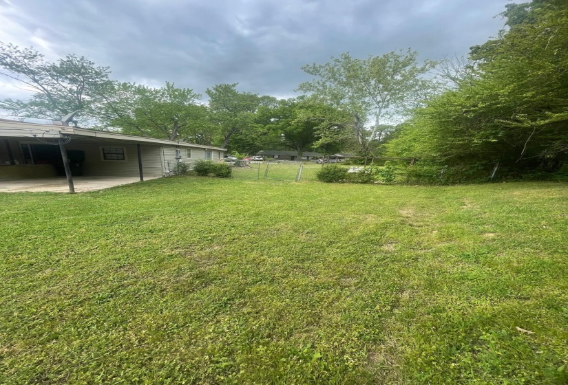 View of yard with an attached carport and a patio area