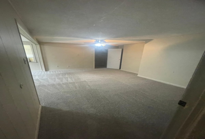 Empty room featuring carpet flooring and ceiling fan