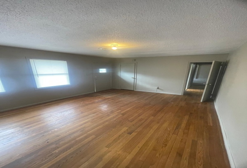Unfurnished bedroom with dark wood-style floors and a textured ceiling