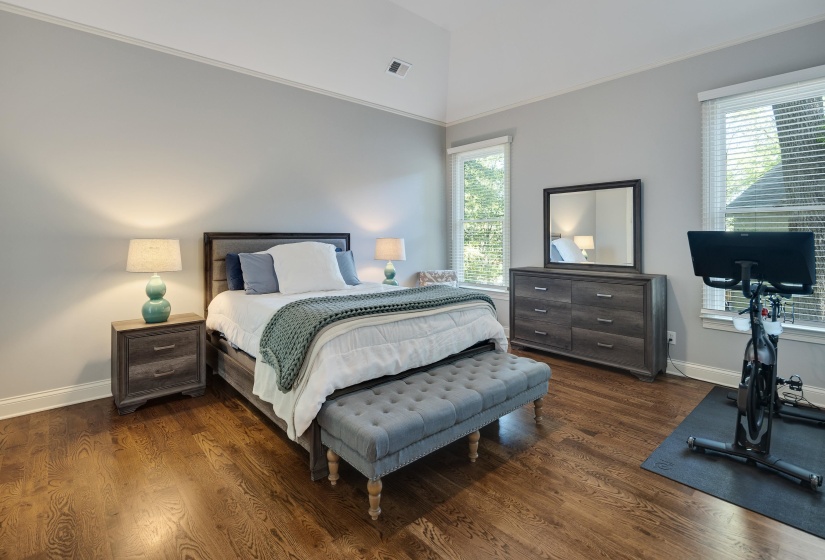 Bedroom featuring ornamental molding, dark wood finished floors, and lofted ceiling