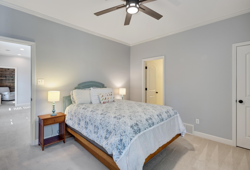 Bedroom with crown molding, a ceiling fan, and light colored carpet
