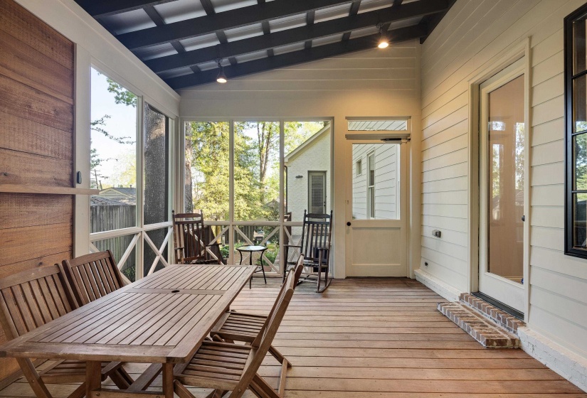 Sunroom with outdoor dining area, lofted ceiling with beams, and a wooden deck