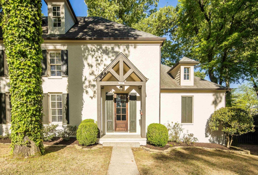 View of front of house featuring a front lawn, a shingled roof, and stucco siding
