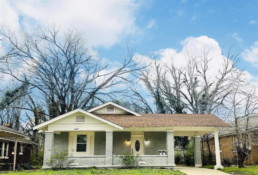 View of front of property featuring brick siding, covered porch, a shingled roof, and a front lawn