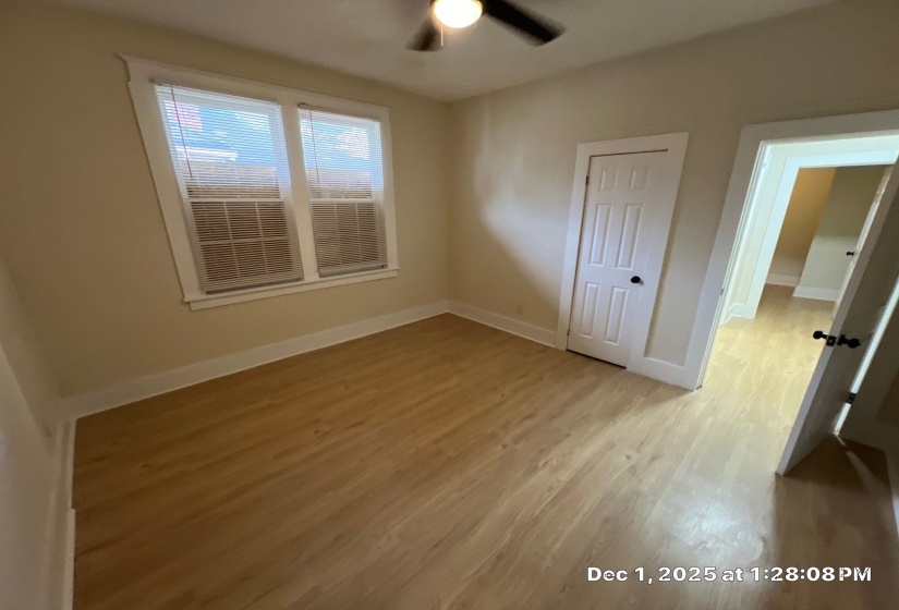 Unfurnished bedroom with light wood-style flooring, a closet, and a ceiling fan