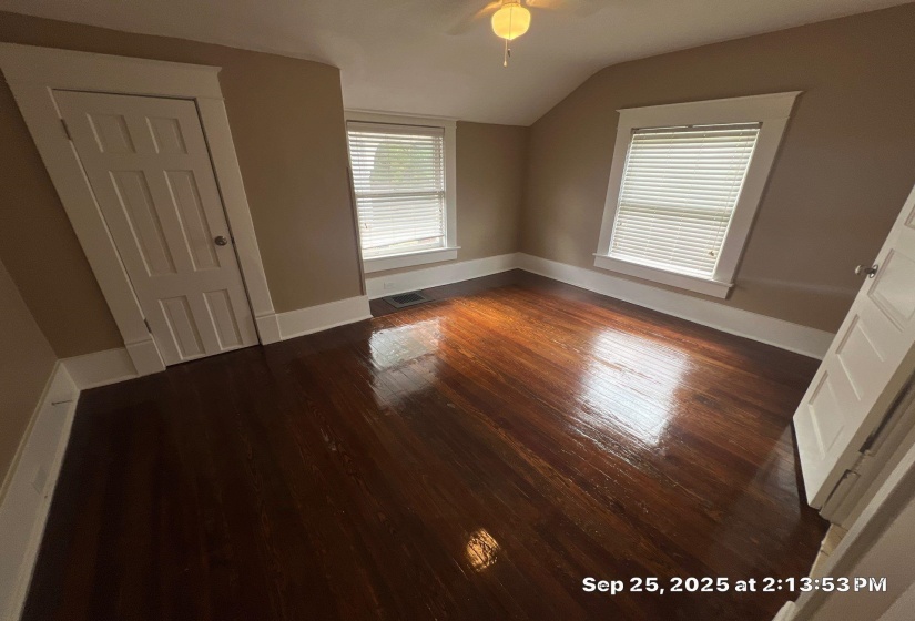 Unfurnished bedroom featuring vaulted ceiling, dark wood-type flooring, and a ceiling fan