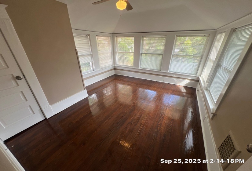 Unfurnished sunroom featuring wood finished floors and vaulted ceiling