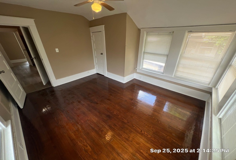 Unfurnished bedroom with dark wood-style floors, a ceiling fan, and lofted ceiling