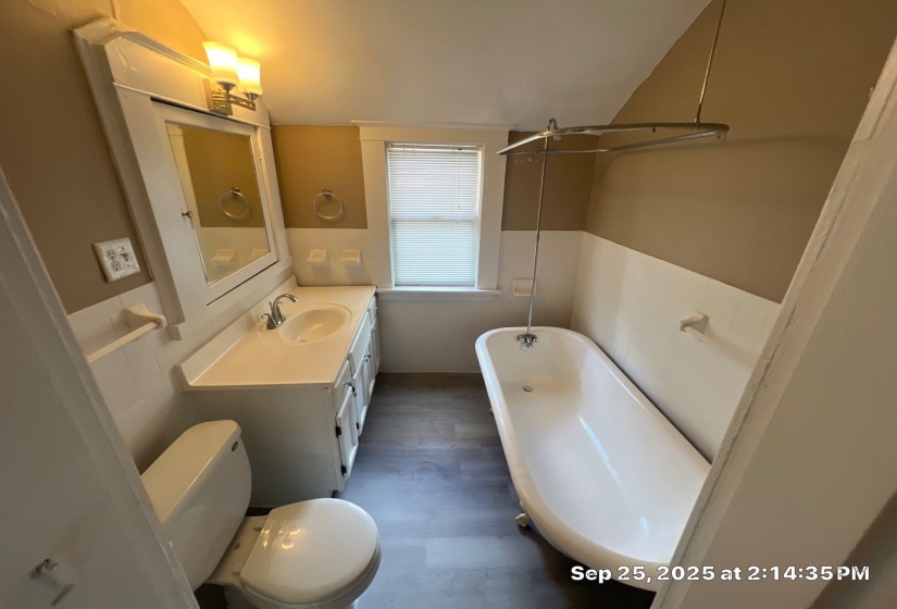 Bathroom featuring a freestanding bath, vanity, and dark wood-type flooring