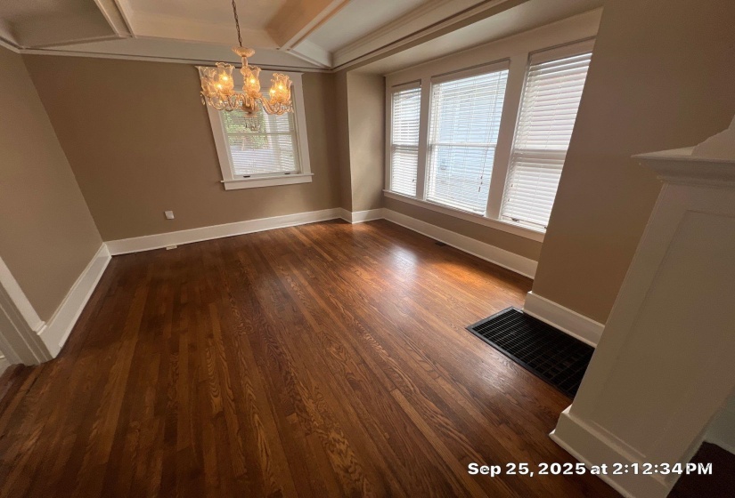 Unfurnished dining area featuring a chandelier and dark wood-style flooring