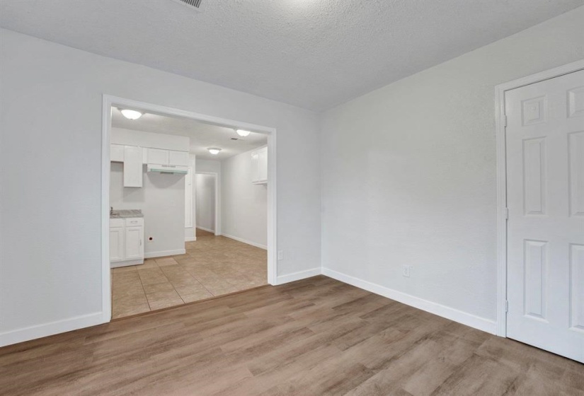 Spare room featuring light wood-type flooring and a textured ceiling
