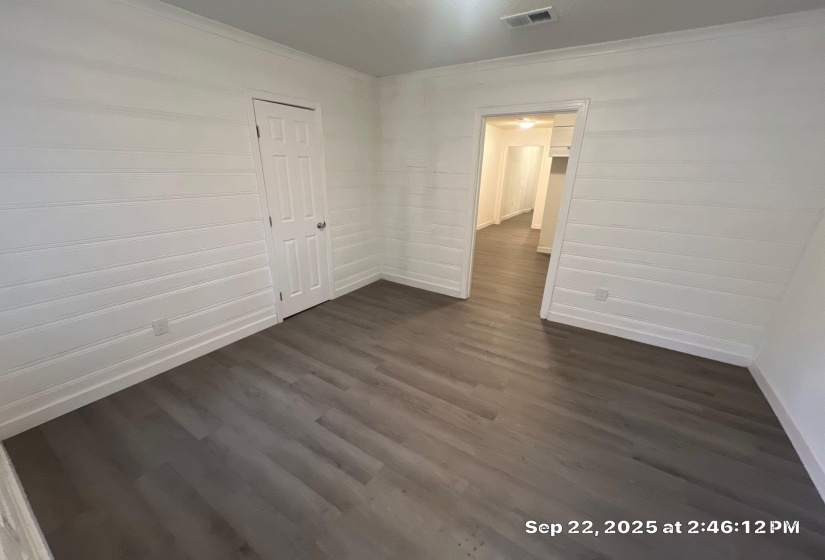Unfurnished room featuring dark wood-style flooring and baseboards