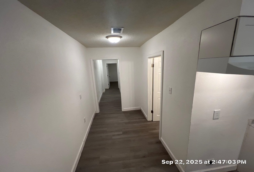 Hallway featuring dark wood-type flooring and a textured ceiling