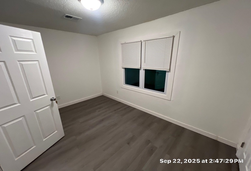 Empty room featuring dark wood-style floors and a textured ceiling