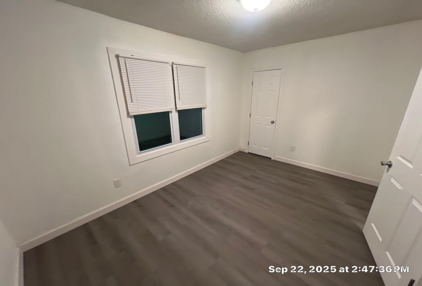 Spare room with dark wood-type flooring and a textured ceiling