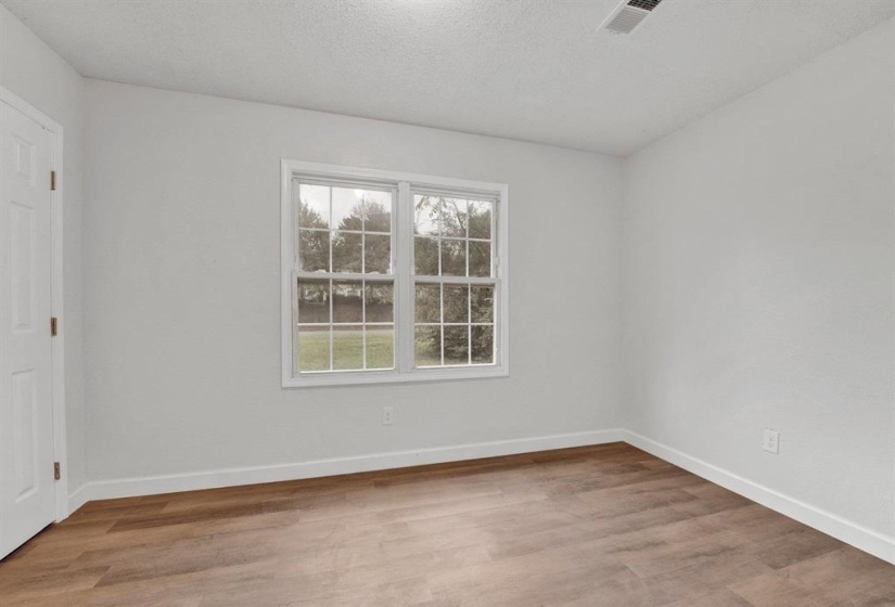Spare room featuring light wood finished floors and a textured ceiling