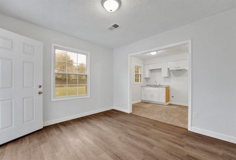 Unfurnished living room featuring a textured ceiling and light wood-style floors