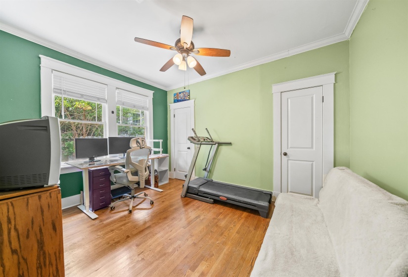 Office space featuring crown molding, light wood-style floors, and ceiling fan
