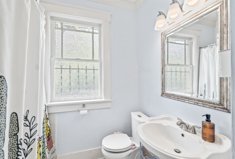 Bathroom featuring a shower with curtain, healthy amount of natural light, and ornamental molding