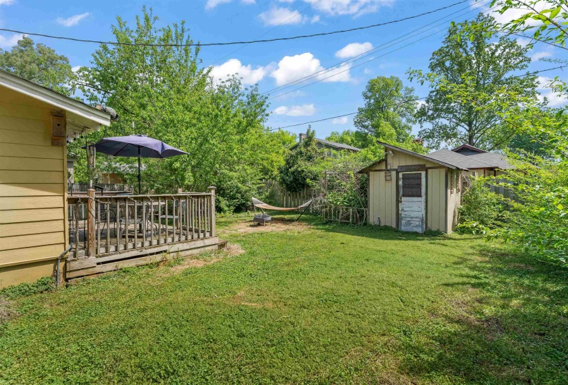 View of yard featuring a deck and a storage shed