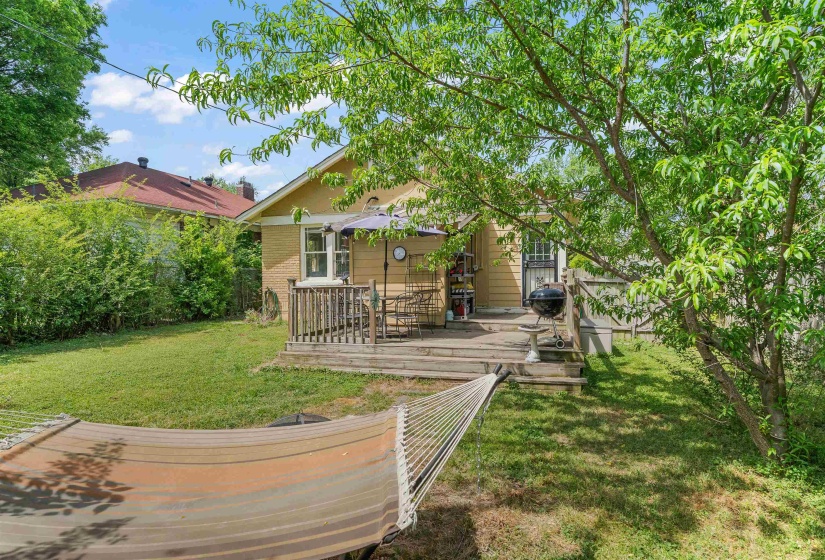Back of property featuring a wooden deck and brick siding