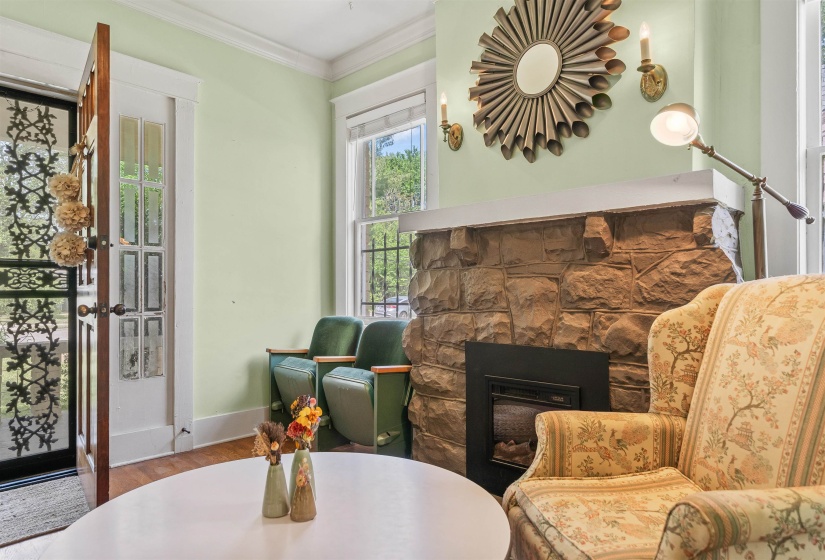 Sitting room with ornamental molding, a fireplace, and wood finished floors