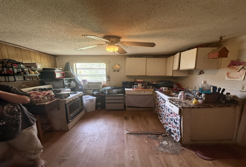 Kitchen featuring light wood-style flooring, white range with gas stovetop, a ceiling fan, and a textured ceiling