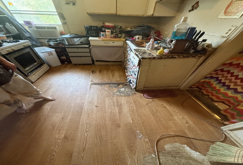 Kitchen with stove, light wood finished floors, and cooling unit